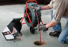 A man is using an electric pipe wrench to fix the hole.