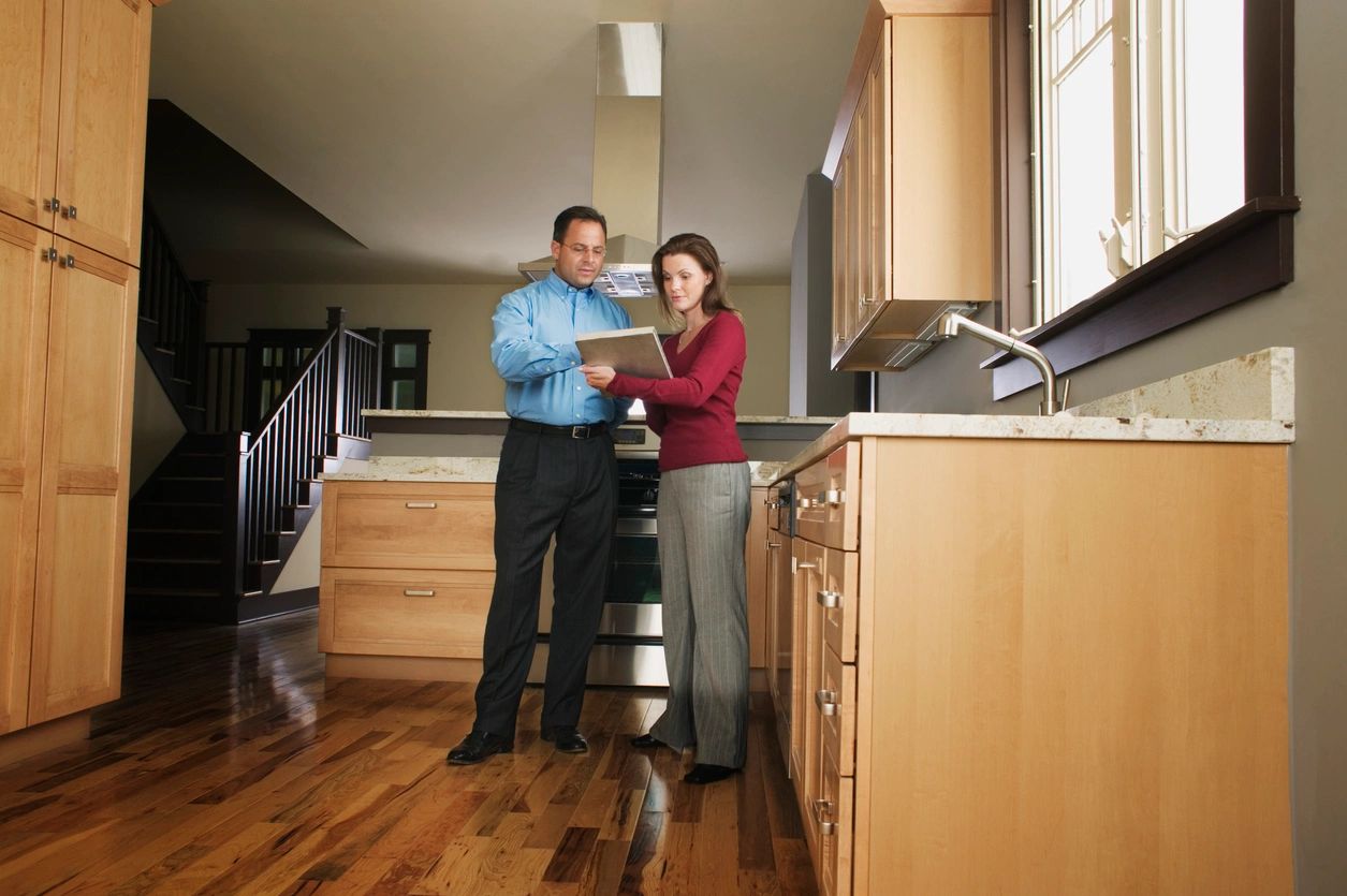 A man and woman standing in the kitchen.