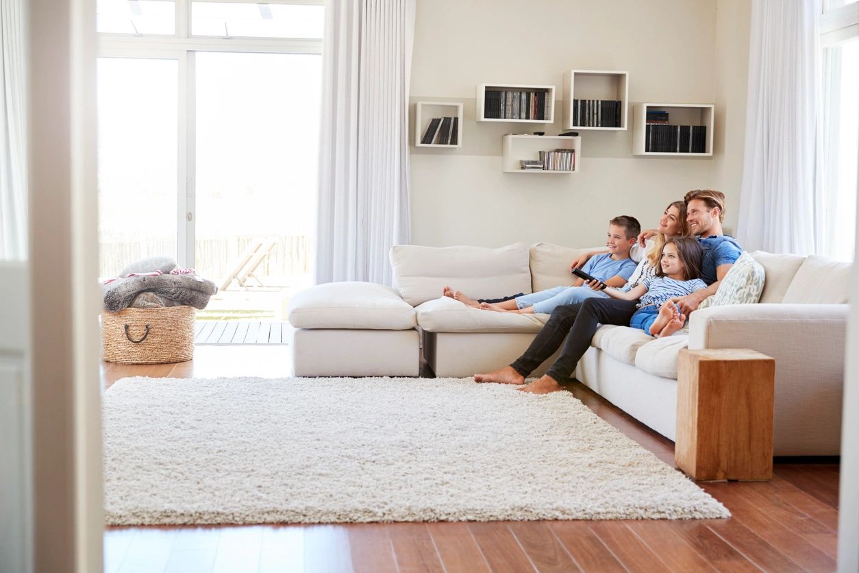 A family sitting on the couch in their living room.